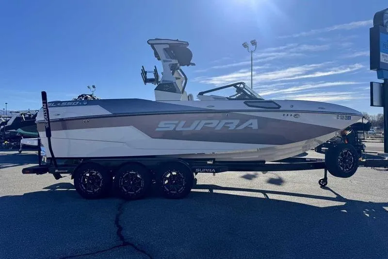 Slide: The Image of 2022 Supra SL boat on trailer under clear blue sky. - 4