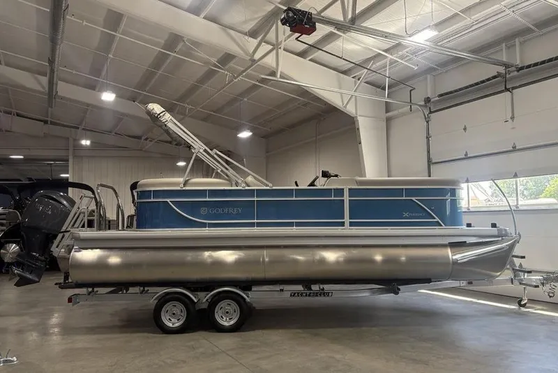 Slide: The Image of 2025 Godfrey Xperience 2286 SBX pontoon boat in a showroom on a trailer. - 10