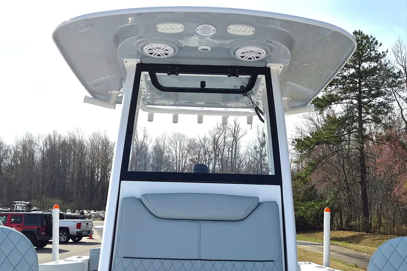 Slide: The Image of 2026 Sportsman Heritage 231 Center Console boat with T-top and speakers, parked outdoors. - 11