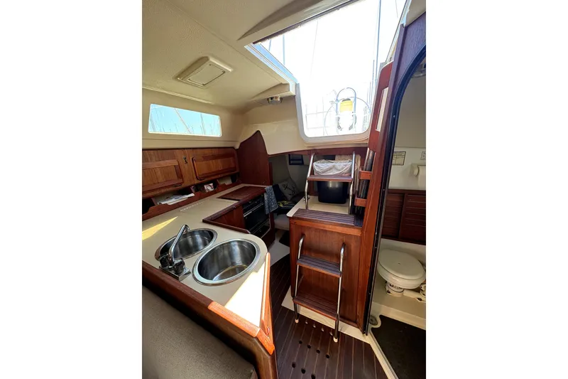 Slide: The Image of 1989 Hunter 30 sailboat bathroom with sink, toilet, and storage cabinets. - 10