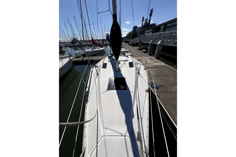 Slide: The Image of 1989 Hunter 30 sailboat docked in marina with city skyline background. - 4