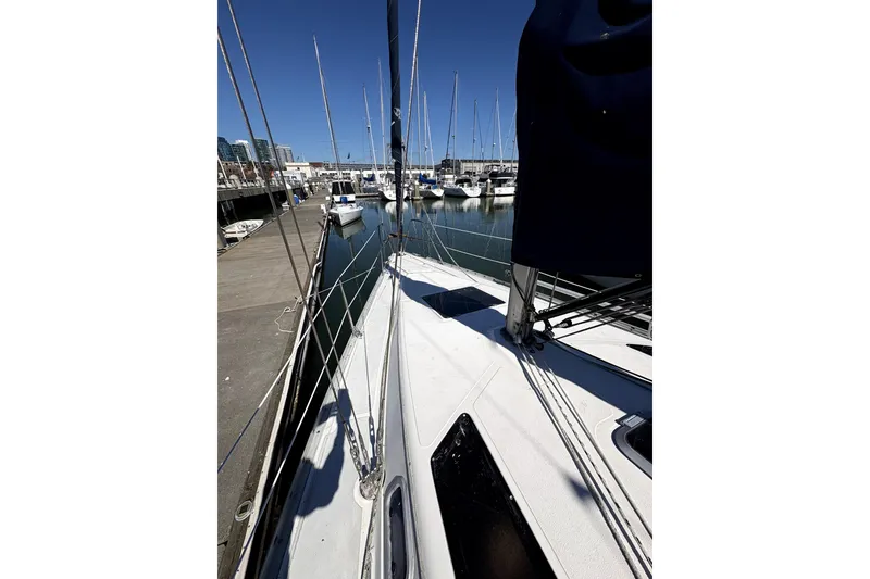 Slide: The Image of 1989 Hunter 30 sailboat docked at marina, featuring a clean white deck and stainless steel ladder. - 5