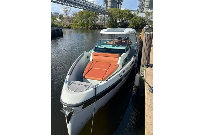 Slide: The Image of 2023 Saxdor 320 GTO boat docked, featuring sleek design and orange seating. - 1
