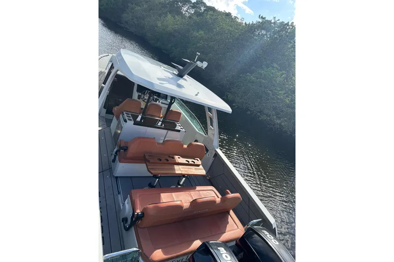 Slide: The Image of 2023 Saxdor 320 GTO boat with sleek design and luxurious seating on a serene waterway. - 17
