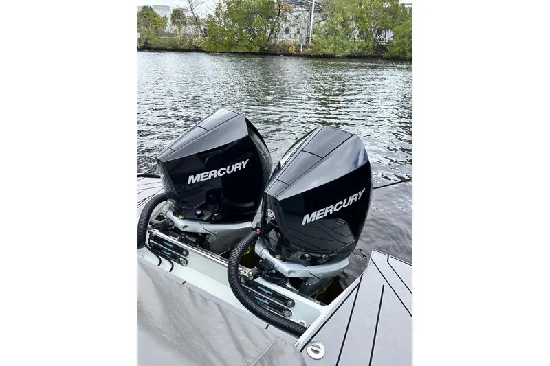 Slide: The Image of Twin Mercury outboard engines on a 2023 Saxdor 320 GTO boat by the water. - 19