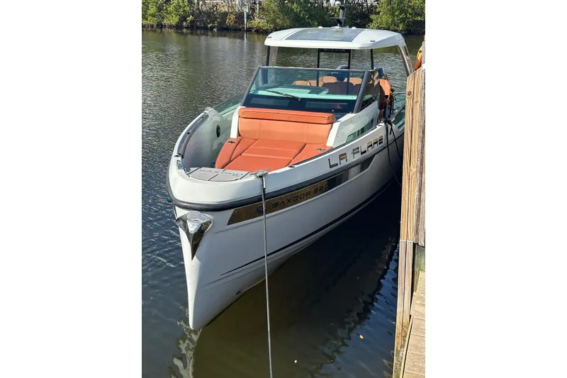 Slide: The Image of 2023 Saxdor 320 GTO boat docked, featuring sleek design and orange seating. - 3