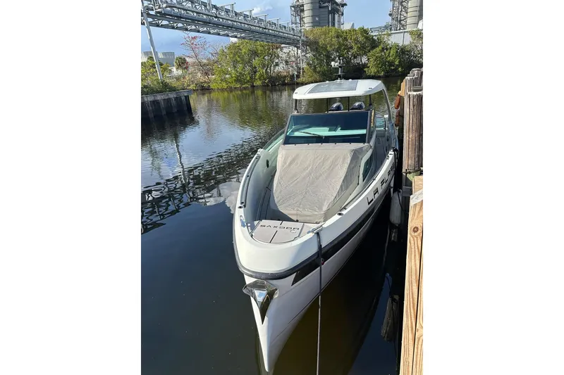 Slide: The Image of 2023 Saxdor 320 GTO boat docked in a serene waterway setting. - 5