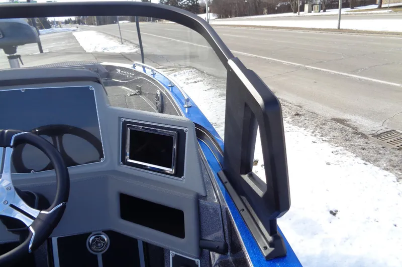 Slide: The Image of 2026 Ranger 620xFS Pro boat dashboard with steering wheel and display, parked on snowy roadside. - 3