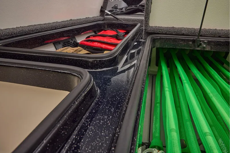 Slide: The Image of Manufacturer Provided Image: 2026 Ranger 620xFS Pro boat storage compartments with life jackets and green rod holders. - 54