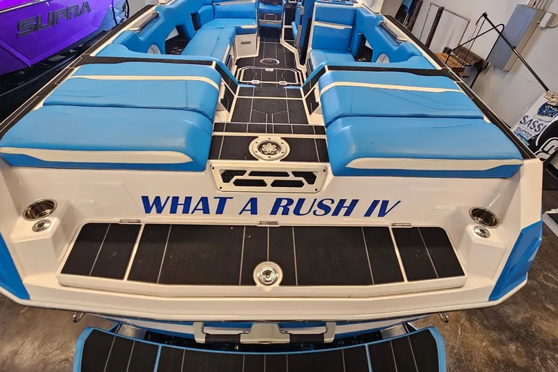 Slide: The Image of 2023 Supra SE 550 boat with blue seating, labeled "What a Rush IV." - 10