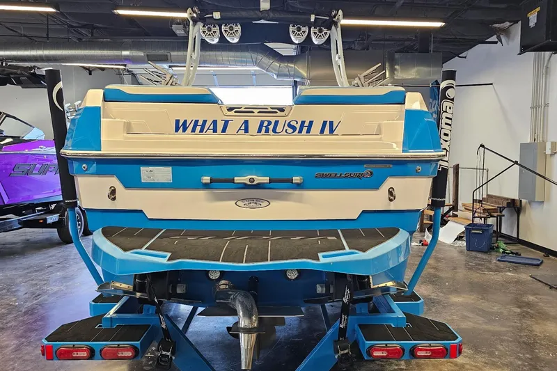 Slide: The Image of 2023 Supra SE 550 boat, blue and white, in showroom with "What A Rush IV" text. - 8