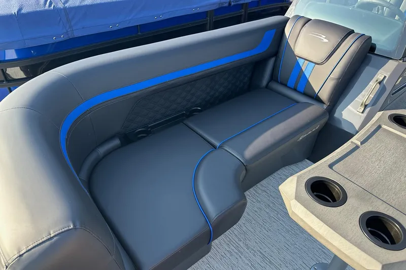 Slide: The Image of Luxurious seating on 2026 Bennington 22 SSR Quad Bench with blue accents and cup holders. - 14