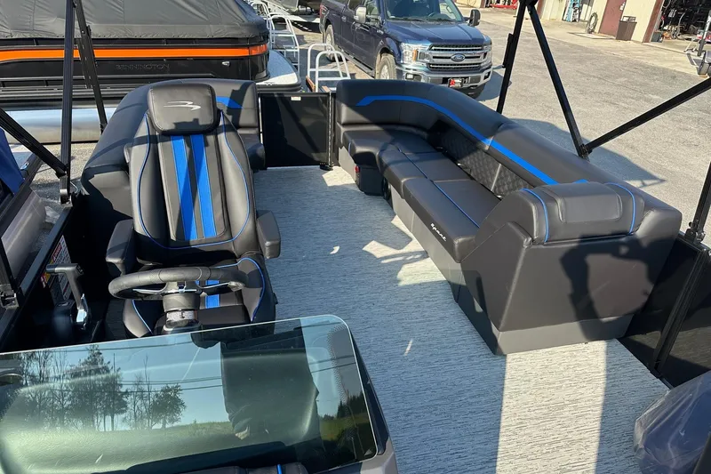 Slide: The Image of 2026 Bennington 22 SSR Quad Bench interior with sleek black and blue seating. - 17