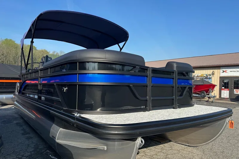 The Image of 2026 Bennington 22 SSR Quad Bench pontoon boat with blue accents, parked outdoors. - 4