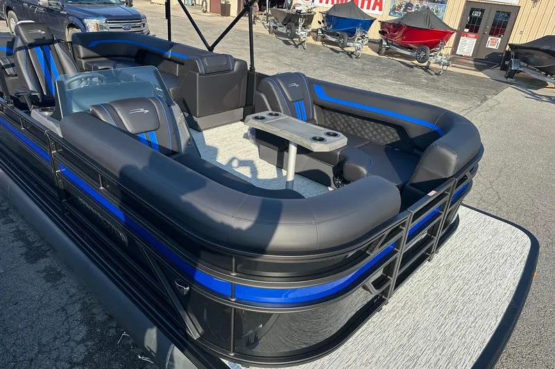 Slide: The Image of 2026 Bennington 22 SSR Quad Bench pontoon boat with sleek black and blue seating. - 8