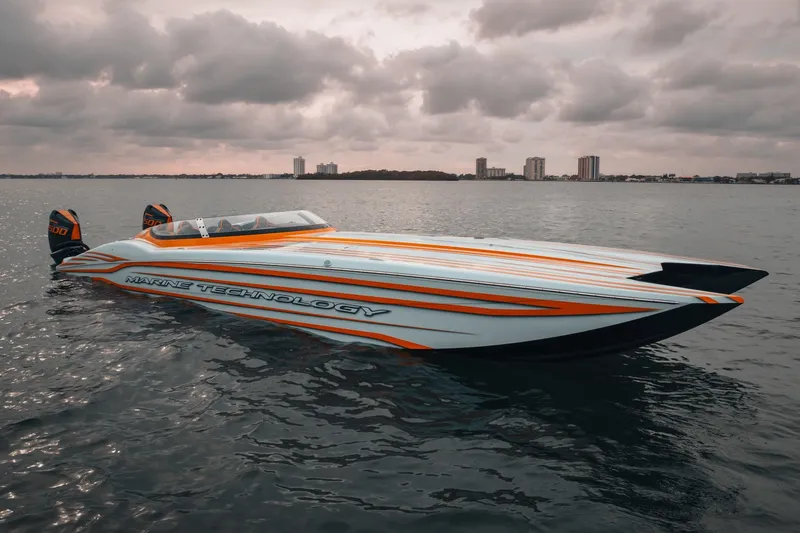 Slide: The Image of 2024 MTI 390X powerboat with sleek design on calm water under cloudy sky. - 4