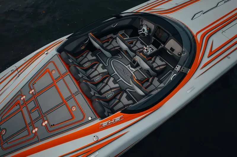 Slide: The Image of 2024 MTI 390X speedboat with sleek orange and gray design, featuring luxurious seating and modern controls. - 7