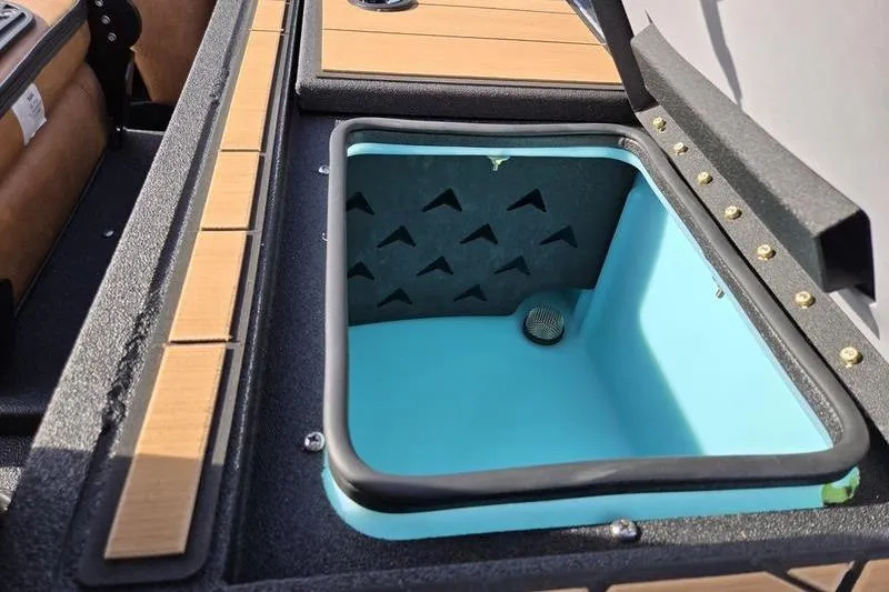 Slide: The Image of Open storage compartment in 2026 Avid 20 Vertex boat, featuring wood accents and blue interior. - 11