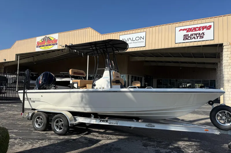 Slide: The Image of 2026 Pathfinder 2200 TRS boat on trailer outside dealership, sunny day. - 3
