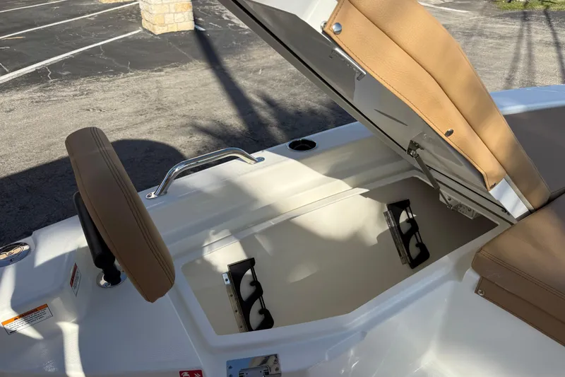 Slide: The Image of 2026 Pathfinder 2200 TRS boat with open storage compartment and tan seating. - 35