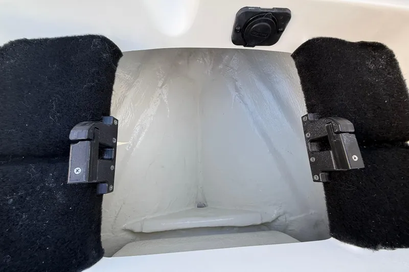 Slide: The Image of Interior compartment of 2026 Pathfinder 2200 TRS boat, featuring black carpeted sides and latch mechanisms. - 40