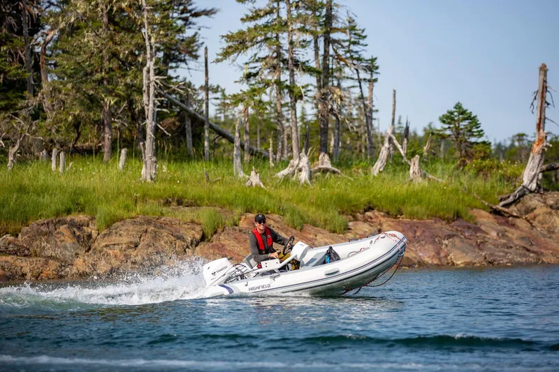 Slide: The Image of Highfield Classic 360 boat 2026 on water near wooded shoreline. - 3