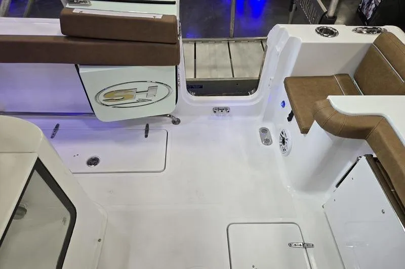 Slide: The Image of 2026 Sea Hunt Gamefish 27 Forward Seating boat interior with brown cushioned seats. - 10