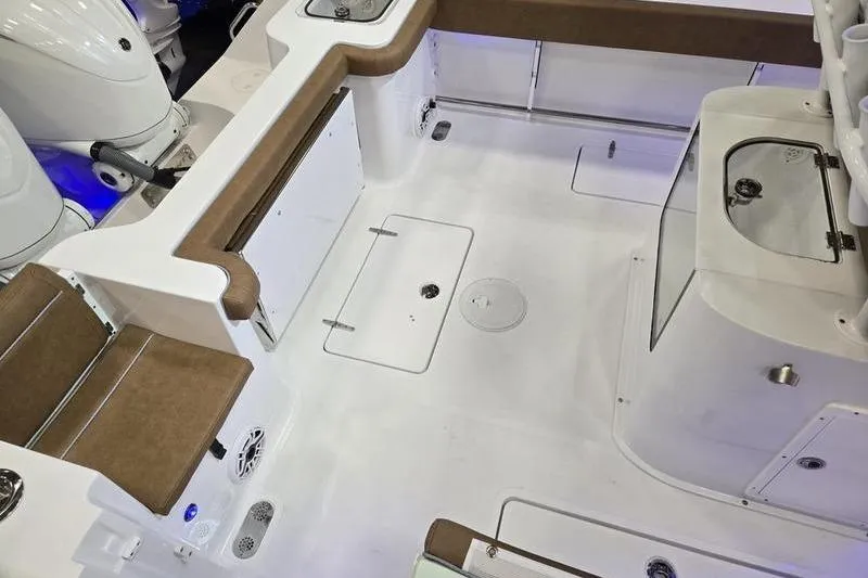 Slide: The Image of 2026 Sea Hunt Gamefish 27 Forward Seating boat interior with brown cushioned seats and storage compartments. - 6