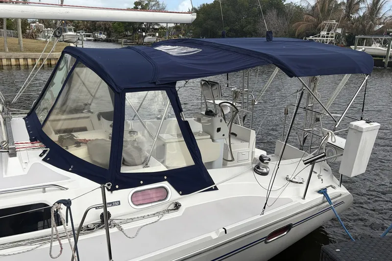 Slide: The Image of 2004 Catalina 36 MkII sailboat with blue canopy docked at marina. - 11