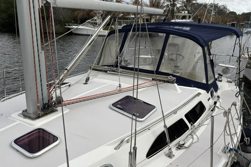 Slide: The Image of 2004 Catalina 36 MkII sailboat with blue canopy docked by the water. - 13