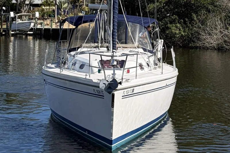 Slide: The Image of 2004 Catalina 36 MkII sailboat on calm water, featuring a sleek white hull and blue accents. - 2