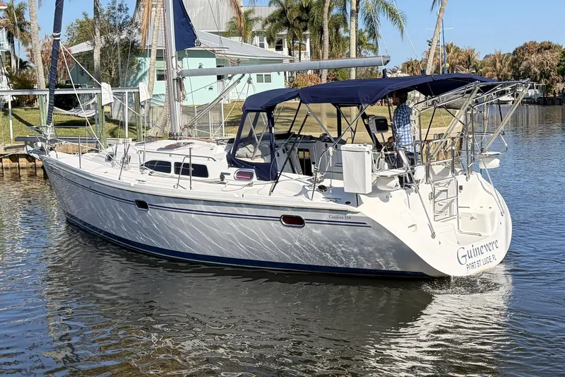 Slide: The Image of 2004 Catalina 36 MkII sailboat on calm water, featuring blue canopy and sleek design. - 3