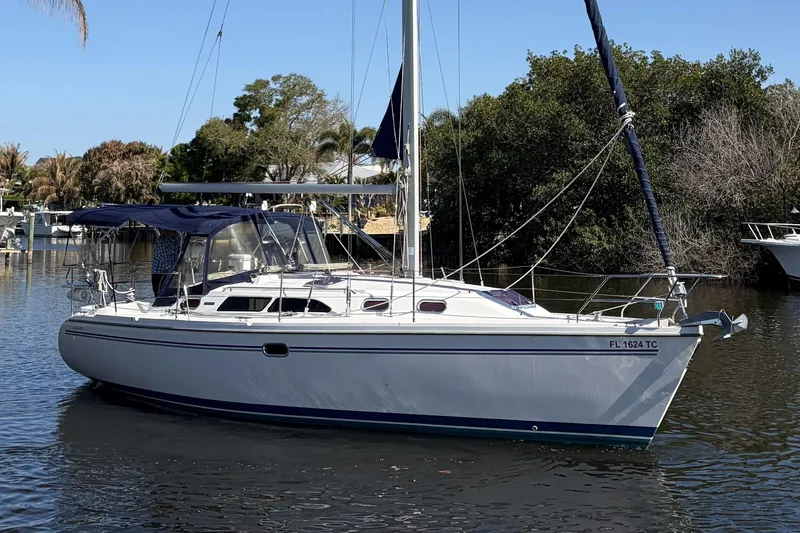 Slide: The Image of 2004 Catalina 36 MkII sailboat on calm water, surrounded by trees. - 4