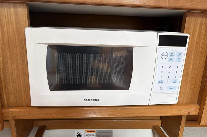 Slide: The Image of White Samsung microwave in a wooden cabinet on a 2004 Catalina 36 MkII. - 44