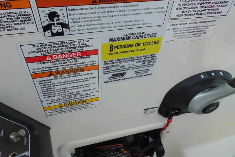 Slide: The Image of 2021 Bayliner VR5 Bowrider I/O safety and capacity labels with control lever. - 18