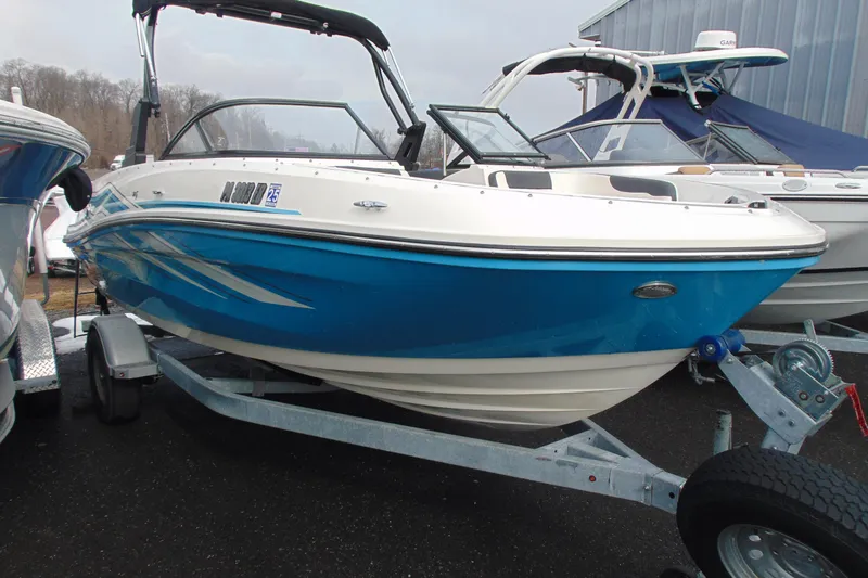 Slide: The Image of 2021 Bayliner VR5 Bowrider I/O boat on trailer, blue and white design. - 3