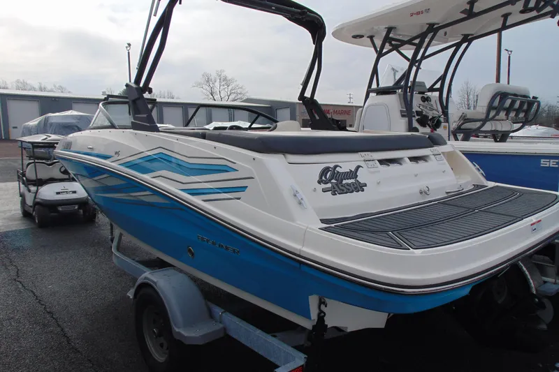 Slide: The Image of 2021 Bayliner VR5 Bowrider I/O boat on trailer, featuring blue and white design. - 4