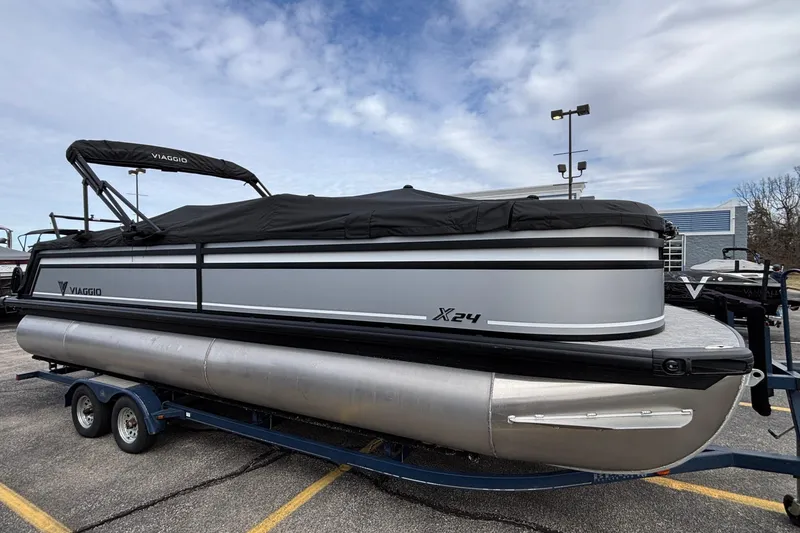 Slide: The Image of 2026 Viaggio X24U pontoon boat with cover on trailer, parked outdoors. - 33