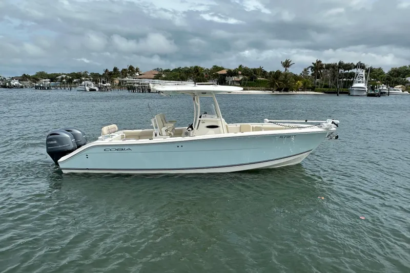 The Image of 2016 Cobia 277 Center Console boat on water, featuring twin Yamaha engines. - 0