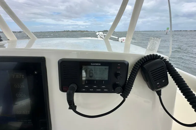 Slide: The Image of 2016 Cobia 277 Center Console boat dashboard with Garmin marine radio and ocean view. - 11