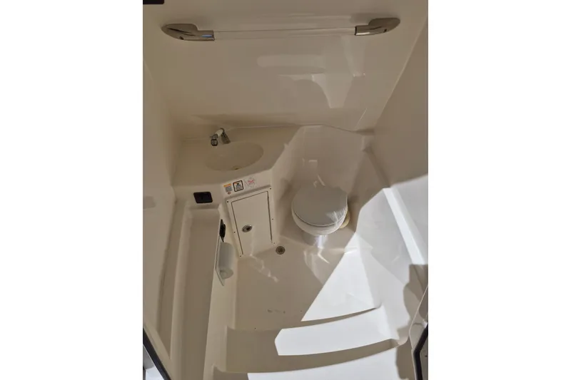 Slide: The Image of 2016 Cobia 277 Center Console boat interior with sink and toilet. - 15