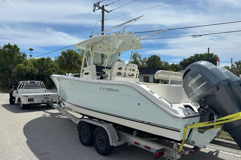 Slide: The Image of 2016 Cobia 277 Center Console boat on trailer, attached to a truck. - 3