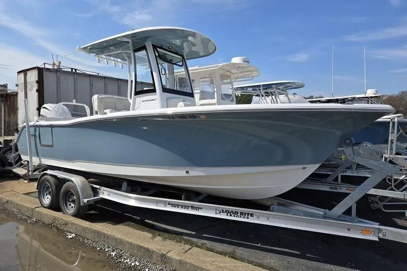 The Image of 2023 Sea Hunt Ultra 239 SE boat on trailer, parked outdoors under clear sky. - 1