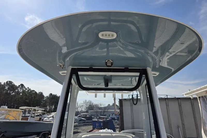 Slide: The Image of 2023 Sea Hunt Ultra 239 SE boat with T-top and LED lights, docked outdoors. - 14