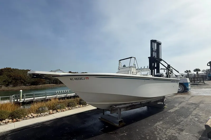 The Image of 1995 Marlin 210 boat on trailer near waterfront, clear sky background. - 1
