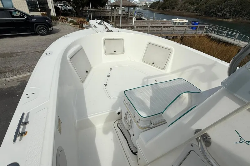 Slide: The Image of 1995 Marlin 210 boat interior with seating and storage compartments at a dockside location. - 11