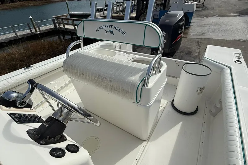 Slide: The Image of 1995 Marlin 210 boat interior with steering wheel and seating at dockside. - 12