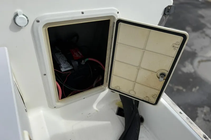 Slide: The Image of Open compartment on a 1995 Marlin 210 boat showing battery and wiring. - 16
