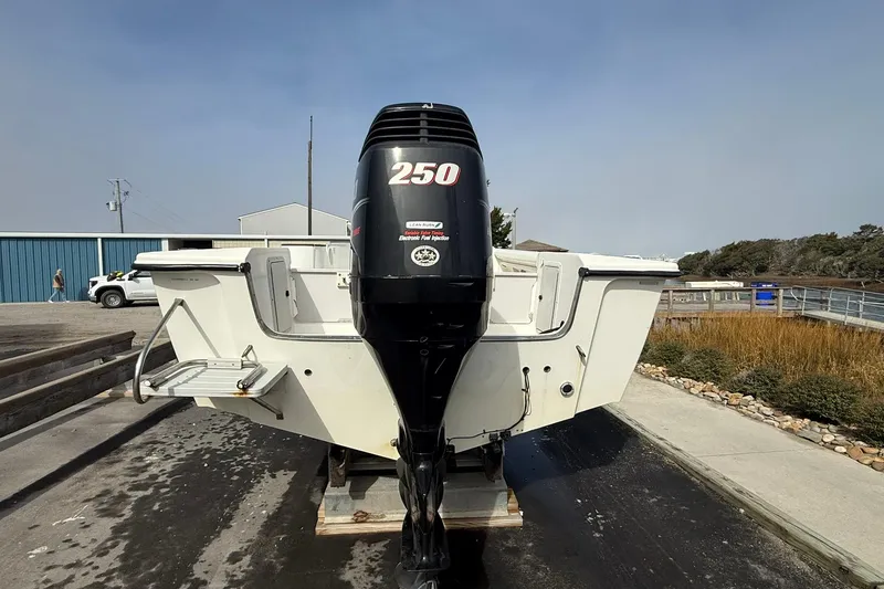 Slide: The Image of 1995 Marlin 210 boat with powerful 250 outboard motor, parked outdoors. - 4