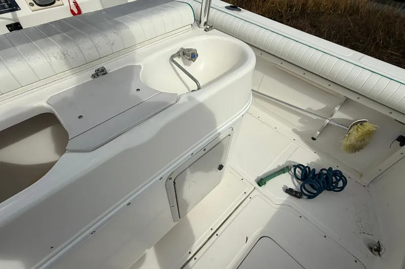 Slide: The Image of Interior of a 1995 Marlin 210 boat with sink, hose, and cleaning brush. - 9